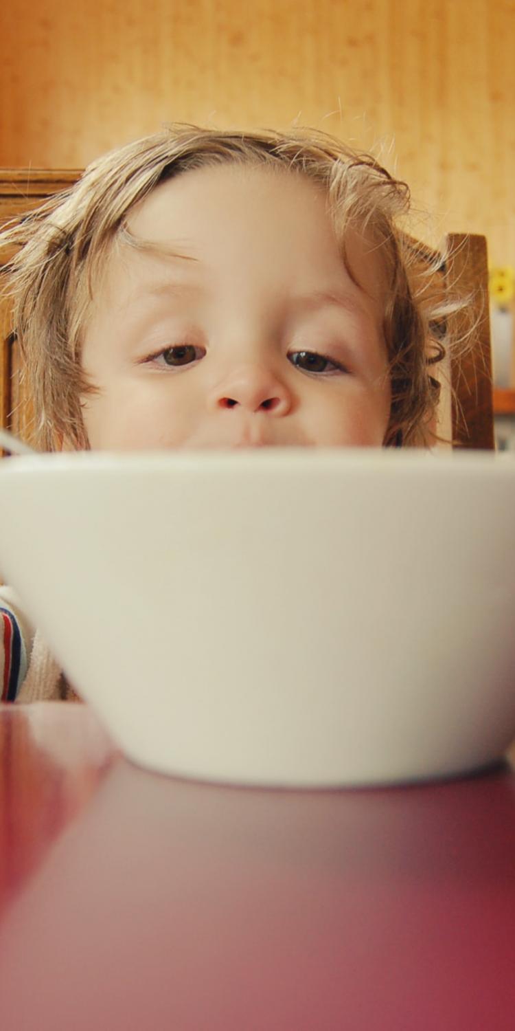 Child behind bowl with spoon