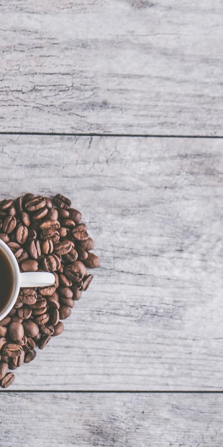 Cup of coffee surrounded by beans